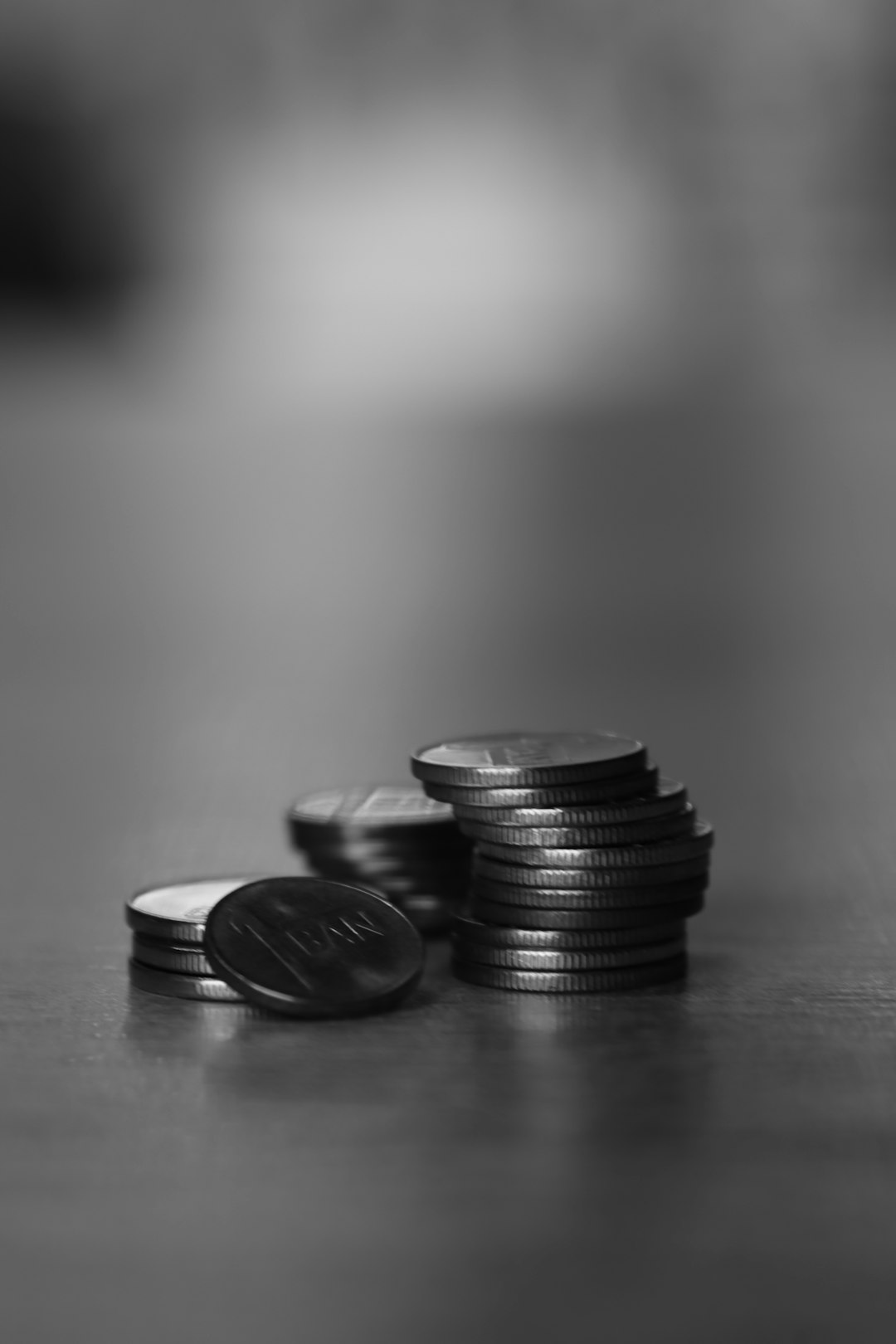 Coins arranged in ascending stacks on a neutral surface, representing wealth growth