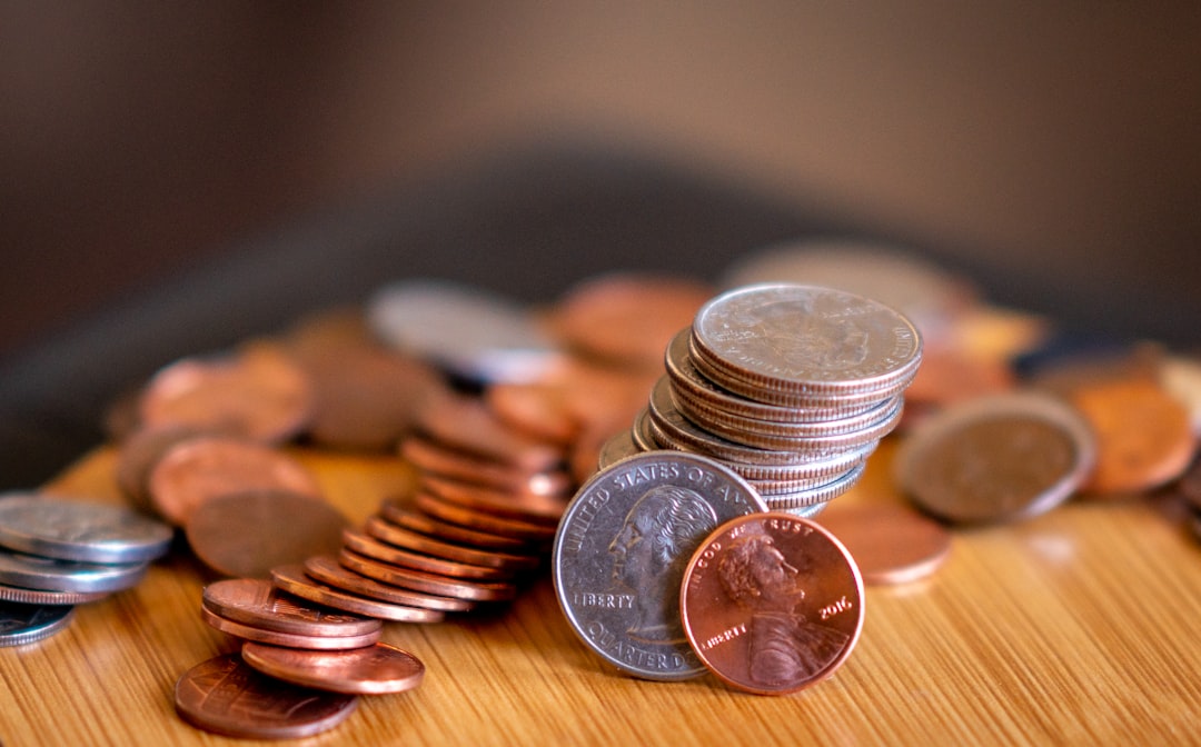 Coins and currency spread on wood in natural light, representing financial planning and growth