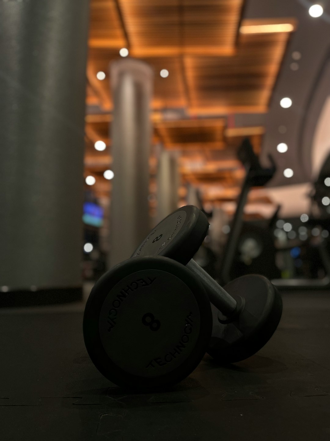 Array of dumbbells and gym equipment in a bright modern fitness facility