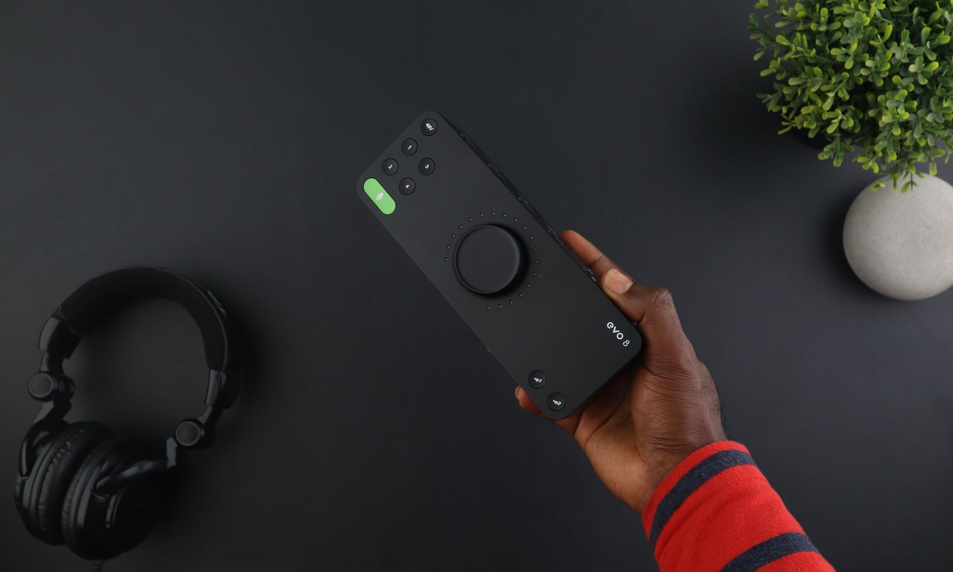 Headphones and portable guitar audio processor on a professional studio desk