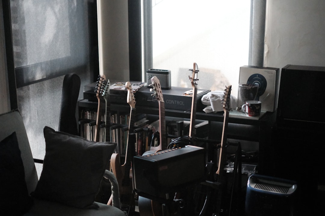 Home practice station with guitar, audio interface, and headphones on a workspace