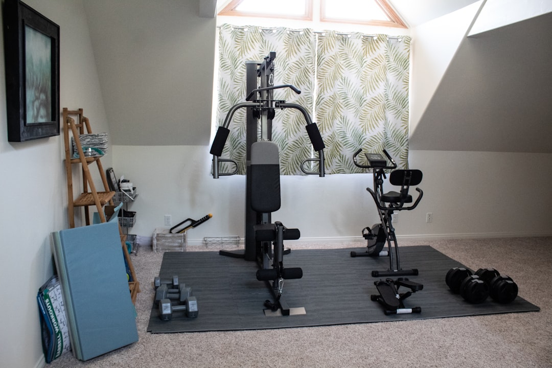Home gym equipment progression from resistance bands through complete setup with rack, barbell, and dumbbells