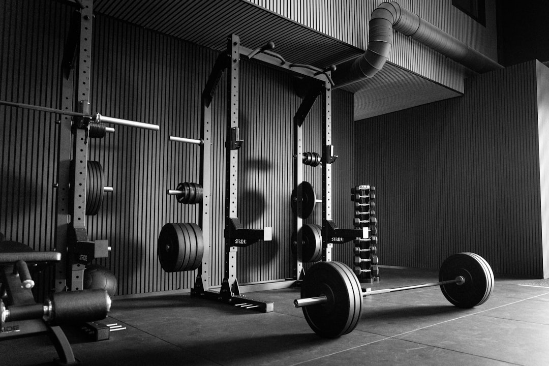 Home garage gym with loaded barbell squat rack and adjustable dumbbells